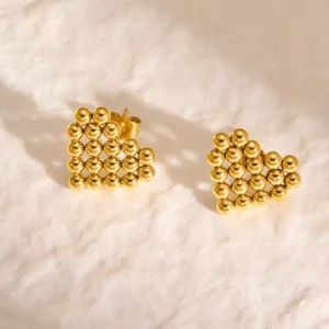 gold heart bead earrings for women on soft background