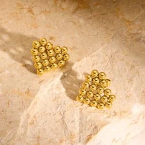 22k gold plated heart bead earrings on stone texture
