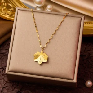 gold leaf pendant necklace for women on textured background